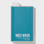 A teal rectangular metal container labeled “Central Coast Laundry Detergent | Mozi,” featuring a white spout on top and infused with a refreshing citrus scent for a clean, vibrant laundry experience.