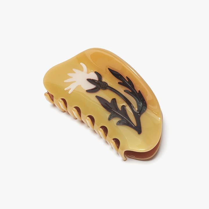 The Winona Irene Fall Rosehip Flower Neutral Acetate Hair Claw is a yellow hair accessory with a white flower and green stem design, shown on a plain white background.