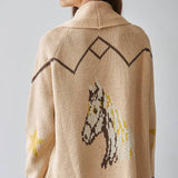 A person viewed from behind is wearing the By Together Knit Sweater Cardigan Top, a beige knit sweater featuring brown geometric patterns, jacquard detailing, and a horse design on the back.