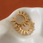 Sablière Sunburst Hoop Earrings: two 18K gold hoop earrings featuring a textured, radiating sunburst design.