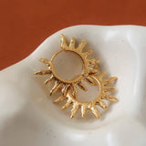 Sablière Sunburst Hoop Earrings: two 18K gold hoop earrings featuring a textured, radiating sunburst design.