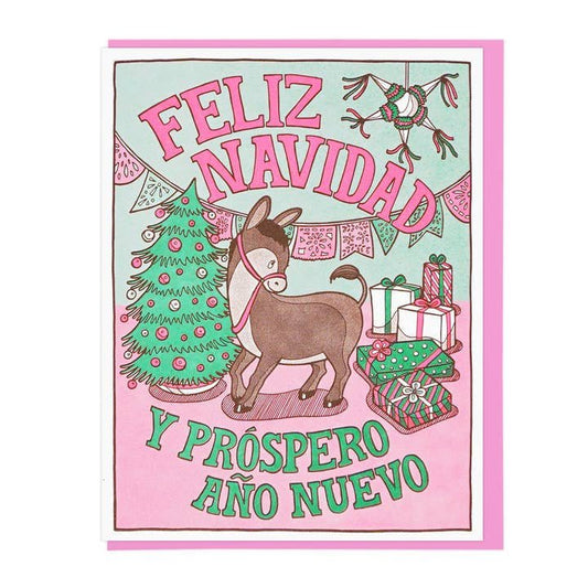 Lucky Horse Press "Feliz Navidad" card features a donkey, Christmas tree, gifts, and festive decor with "Feliz Navidad y Próspero Año Nuevo" in bold pink and green. Letterpress printed; blank inside for your message.