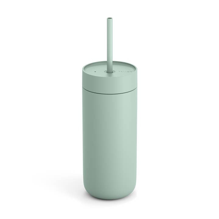 The Fellow Carter Cold Tumbler, a matte light green double-wall vacuum reusable cup with matching lid and straw, is shown standing upright against a plain white background.