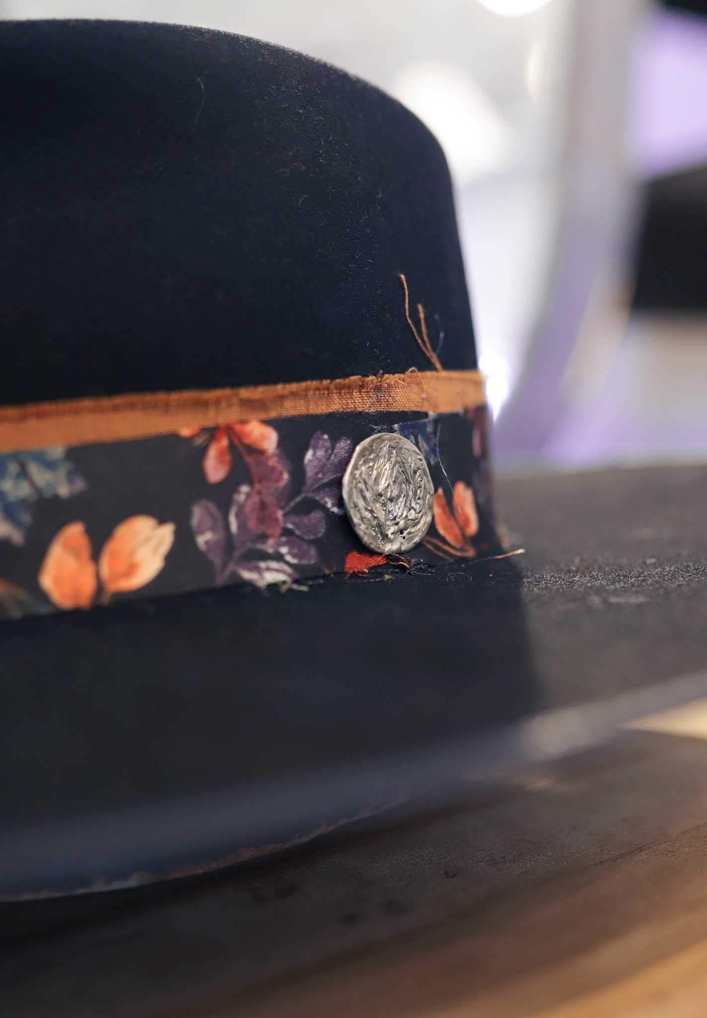 A close-up of the Easy Drifter Felt Hat | Navy Front Pinch, featuring a delicate floral hat band.