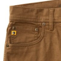 Close-up of the upper front section of Duck Head's Field Canvas Five-Pocket pants in brown, featuring a small yellow logo tag on the coin pocket and visible belt loops.