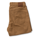 Folded pair of Duck Head Field Canvas Five-Pocket chinos in brown, classic fit, featuring a visible back pocket and a leather patch on the waistband.