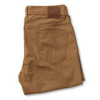 Folded pair of Duck Head Field Canvas Five-Pocket chinos in brown, classic fit, featuring a visible back pocket and a leather patch on the waistband.
