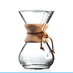 The Chemex Filter Drip Coffeemaker (CM-6A) features a clear design with a wooden collar and leather tie, holding six cups. It is shown against a white background with a light blue stripe at the bottom.