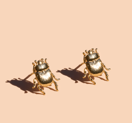 The Peter and June Fortune Beetle Studs, 18k gold plated and beetle-shaped, are shown against a plain beige background.