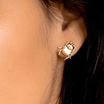 Close-up of a person's ear wearing the Fortune Beetle Studs by Peter and June, 18k gold plated and beetle-shaped.