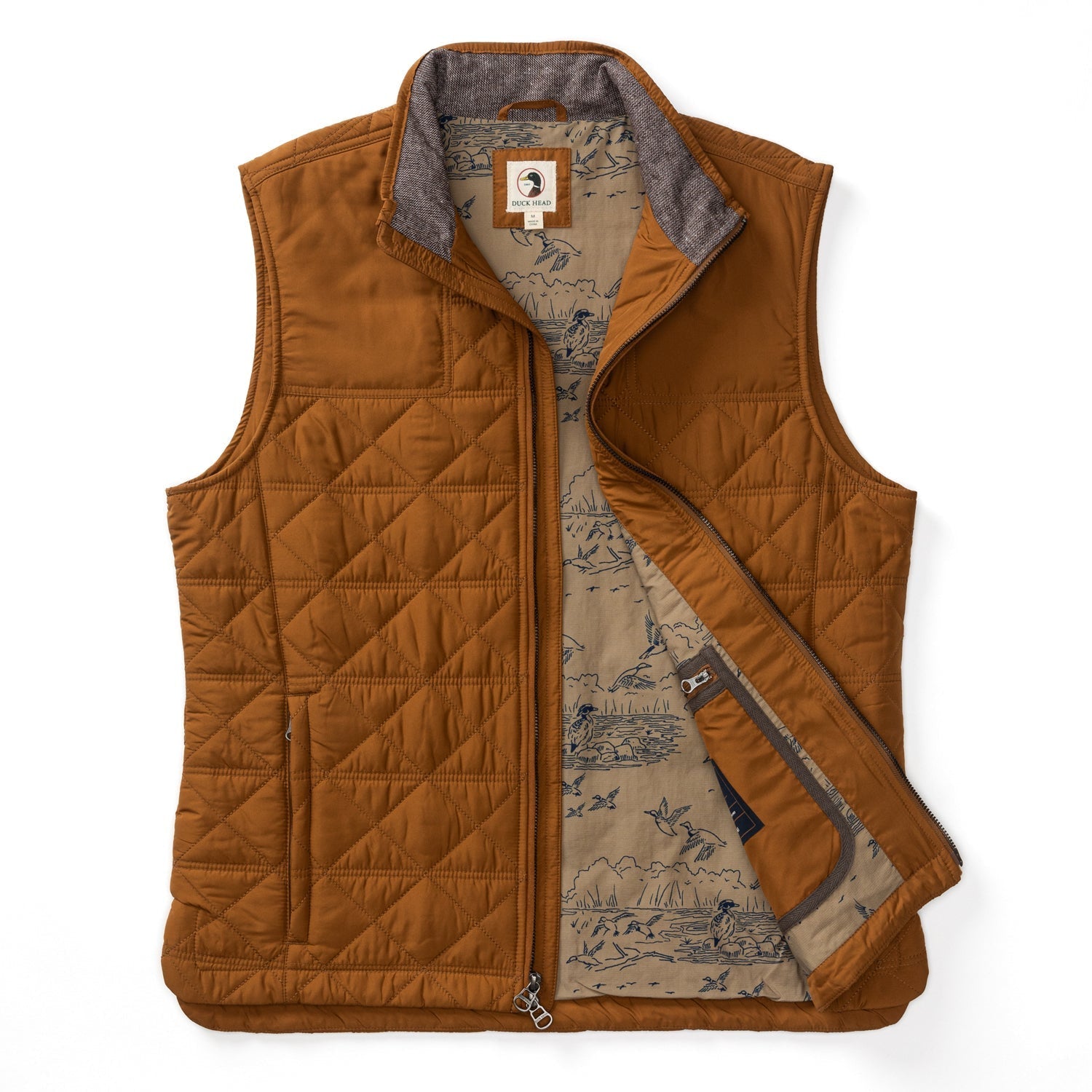 The Duck Head Fremont Sport Performance Quilted Vest is a rust-colored, lightweight insulated vest with a zipper, standing collar, beige nature-print lining, and PrimaLoft Black Insulation for warmth.