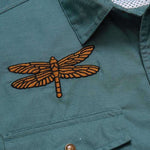 Close-up of the teal Howler Brothers Gaucho Snapshirt | Enter the Dragons, featuring a dragonfly patch embroidered above the chest pocket.