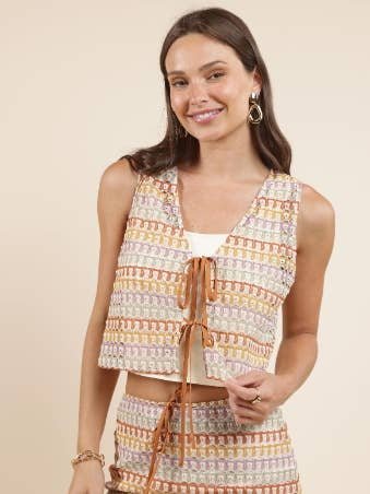 Model wearing the Gilded Sky Front Ties Sleeveless Top by Sadie And Sage, styled with a matching high-waisted skirt, against a plain beige background.