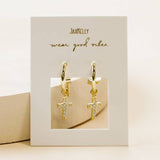 Gold Hoop Cross Earrings by JaxKelly: hypoallergenic gold hoops with small, crystal-studded cross pendants, displayed on a JaxKelly card reading "wear good vibes.