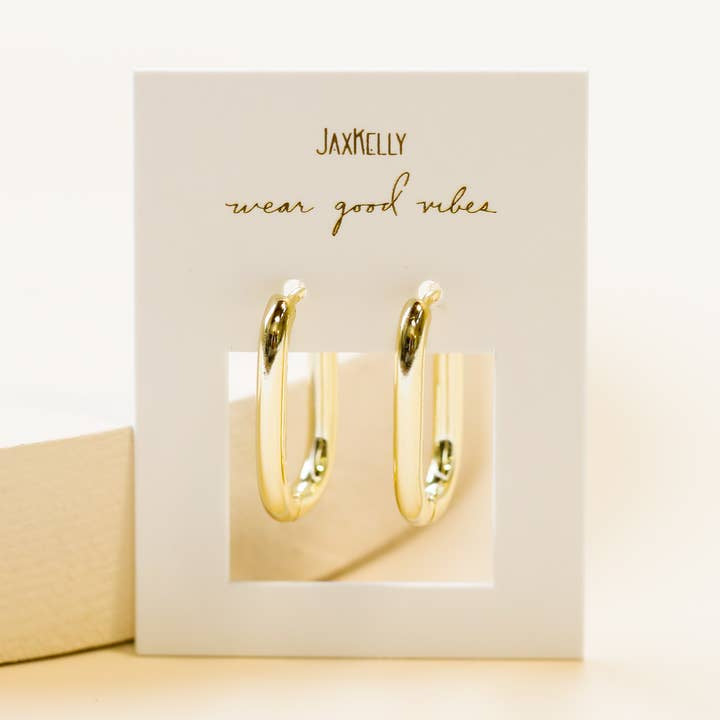 A pair of hypoallergenic, tarnish-free Gold Hoop - Large Rectangle Earrings by JaxKelly, displayed on a white card with "wear good vibes" in gold script.