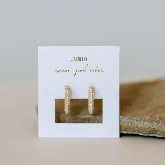 A pair of Gold Hoop - Pave earrings by JaxKelly, featuring gold-plated square hoops with small clear cubic zirconia stones, displayed on a white "wear good vibes" JaxKelly card.
