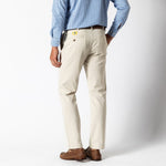 Someone in a blue checkered shirt, brown shoes, and Duck Head Gold School Chino (Big Gold Patch) khakis stands with their back to the camera against a plain background.