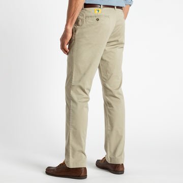 Someone is shown from the back wearing Duck Head’s Gold School Chino (Big Gold Patch) khakis, brown shoes, and a blue checkered shirt against a plain white background, reflecting classic American heritage style.