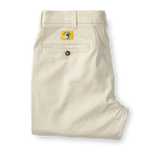 A pair of Duck Head Gold School Chino (Big Gold Patch) khakis in light beige, featuring a back pocket with button closure and a bold yellow patch above the pocket—celebrating classic American heritage style.