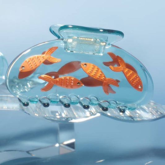 The Winona Irene Goldfish Women's Hair Claw in crystal clear blue acetate features five charming orange goldfish decorations inside, shaped like a fish tank.
