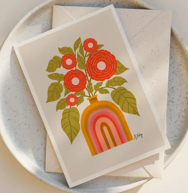 The Good Company Floral Blank Greeting Card by Annie Bailey Art features red flowers and green leaves in a brown, rainbow-patterned vase—designed by a Montana artist.