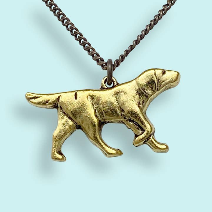 The Good Dog Necklace by Ornamental Things features a charming dog pendant on an aged brass chain, displayed against a light blue background.