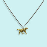 The Good Dog Necklace by Ornamental Things features a charming dog pendant on an aged brass chain, shown against a light blue background.