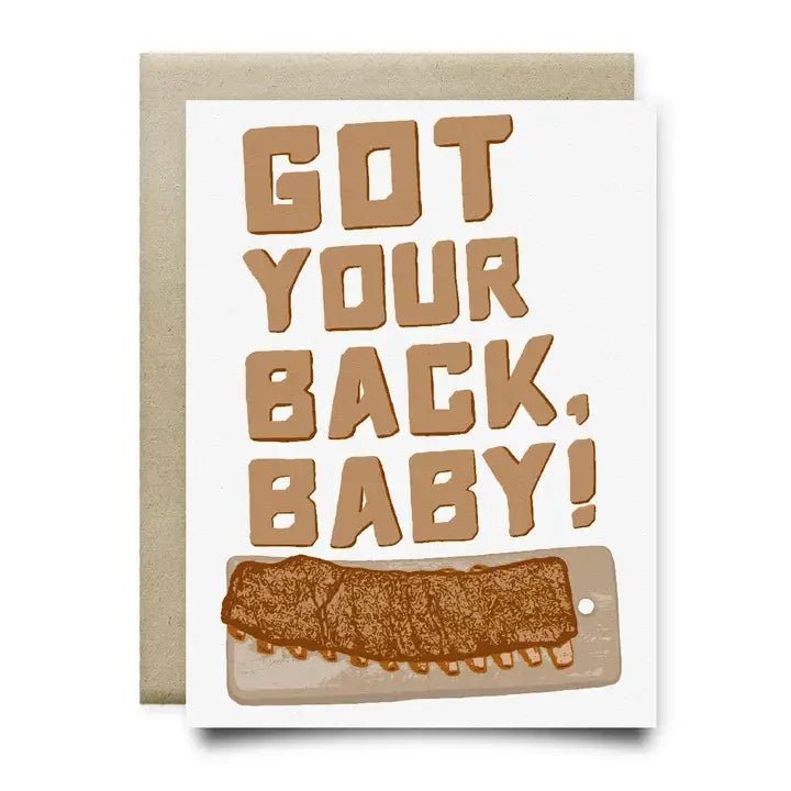 The "Got your back baby" A2 greeting card by Anvil Cards features bold brown text above a hand-drawn rack of ribs on a cutting board, all printed on sustainable linen paper.