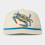 The Duck Camp Grandpa Hat features an embroidered blue crab on beige fabric, blue trim above the visor, and an adjustable snapback for a comfortable fit.