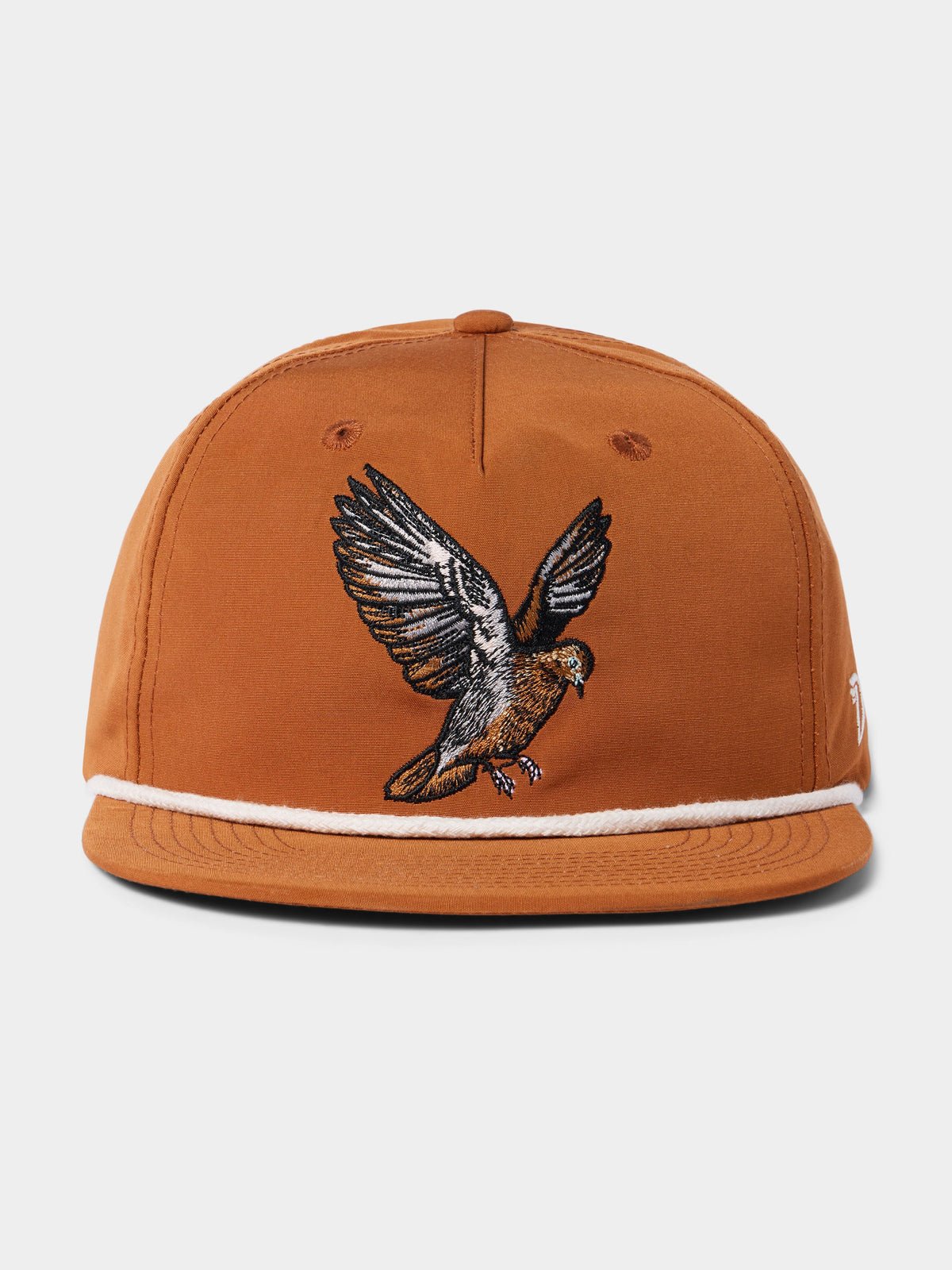 The Grandpa Hat | Dove by Duck Camp is a brown snapback cap with white trim and an embroidered bird with outstretched wings, inspired by dove poppers. Features an adjustable fit.