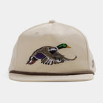 The Grandpa Hat | Mallard by Duck Camp is a beige hat with an embroidered flying duck, featuring an adjustable snapback and durable polyester shell.