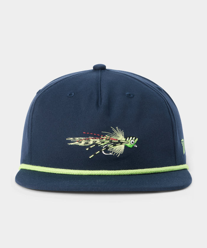 The Grandpa Hat Popper by Duck Camp is a navy blue 5-panel snapback featuring a green fishing fly embroidered on the front and a light green trim along the adjustable visor.