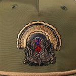 Close-up of the Duck Camp Grandpa Hat | Turkey, an olive green hat with an embroidered turkey head and colorful tail on the front. Features an adjustable snapback for a comfortable fit.