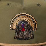 Close-up of the Duck Camp Grandpa Hat | Turkey, an olive green hat with an embroidered turkey head and colorful tail on the front. Features an adjustable snapback for a comfortable fit.