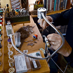 At a workbench, someone uses the Mollyjogger Guide Curated Fly Set, surrounded by organized tools and materials, ready to tie flies and prepare for an exciting day of trout fishing.
