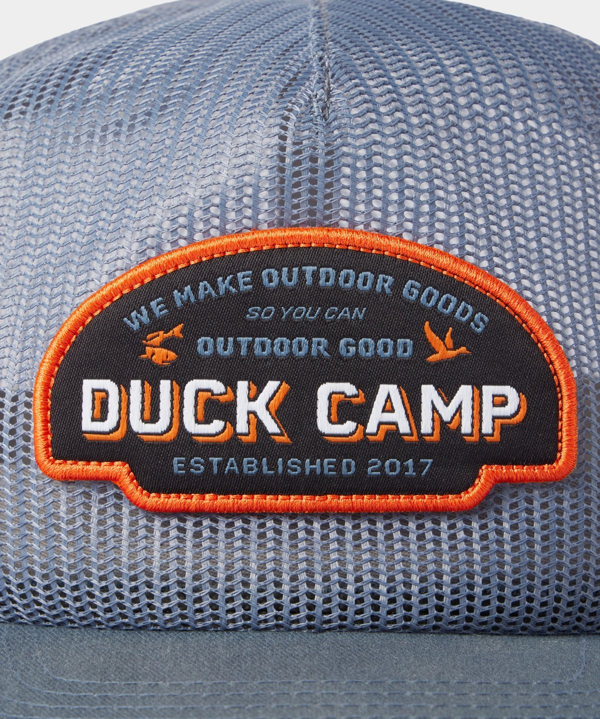 Close-up of the Duck Camp Gulf Trucker | Cast & Blast mesh hat, featuring a patch with “Duck Camp. We make outdoor goods so you can outdoor good. Established 2017.” Breathable and adjustable snapback for a perfect fit.