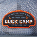 Close-up of the Duck Camp Gulf Trucker | Cast & Blast mesh hat, featuring a patch with “Duck Camp. We make outdoor goods so you can outdoor good. Established 2017.” Breathable and adjustable snapback for a perfect fit.