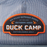 Close-up of the Duck Camp Gulf Trucker | Cast & Blast mesh hat, featuring a patch with “Duck Camp. We make outdoor goods so you can outdoor good. Established 2017.” Breathable and adjustable snapback for a perfect fit.