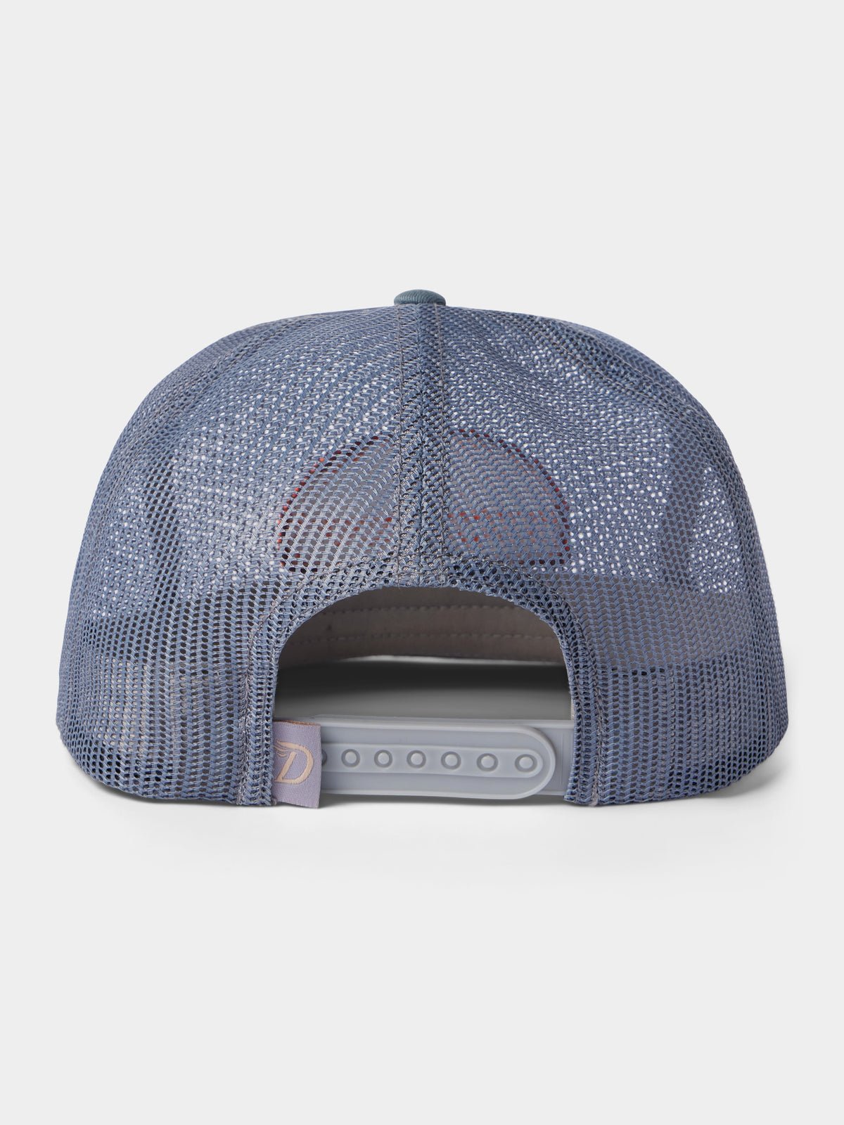 The Gulf Trucker | Cast & Blast by Duck Camp is a blue mesh hat shown from the back, featuring an adjustable snapback closure and a small fabric tag on the left side for added detail.