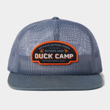 The Gulf Trucker | Cast & Blast by Duck Camp is a blue mesh hat featuring an adjustable snapback and a front patch that reads "Duck Camp" and "We Make Outdoor Goods So You Can Outdoor Good, Established 2017.