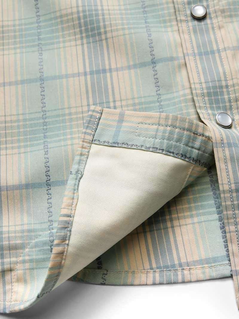 Close-up of a pastel plaid H Bar B Snapshirt by Howler Brothers, featuring pearl snaps, visible pocket interior, and detailed edge stitching.