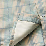 Close-up of a pastel plaid H Bar B Snapshirt by Howler Brothers, featuring pearl snaps, visible pocket interior, and detailed edge stitching.