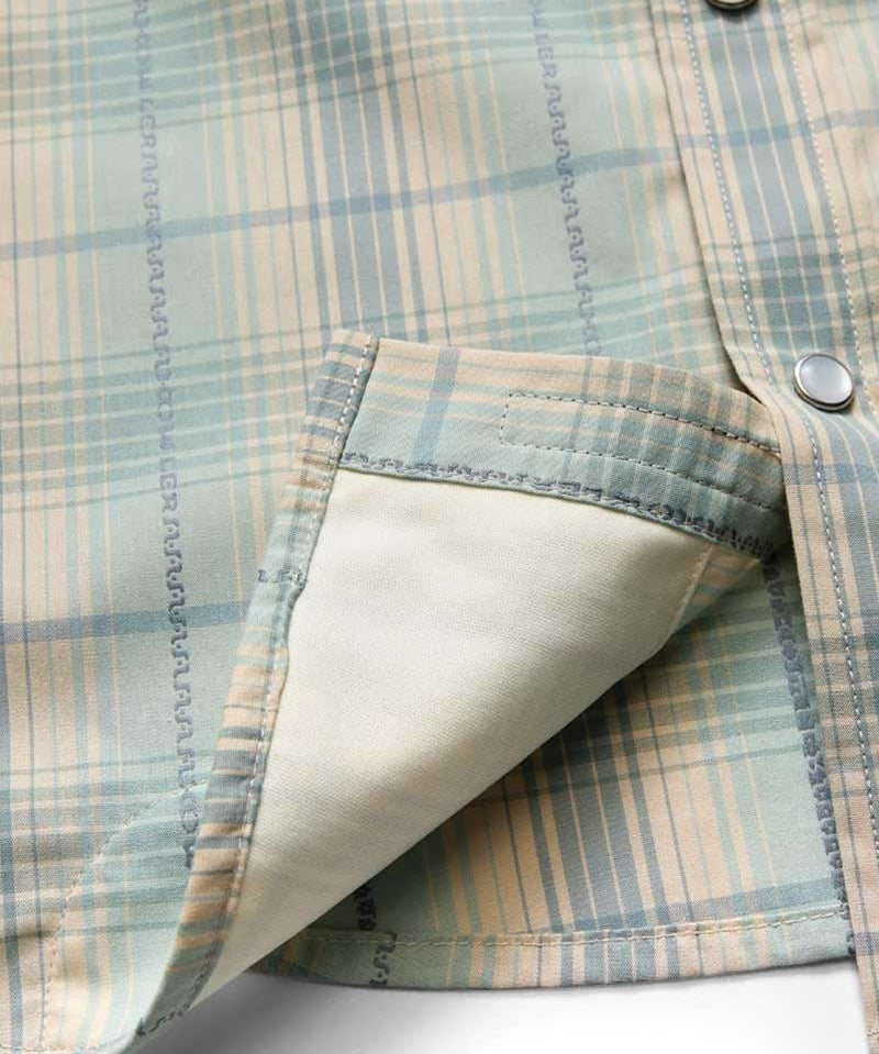 Close-up of a pastel plaid H Bar B Snapshirt by Howler Brothers, featuring pearl snaps, visible pocket interior, and detailed edge stitching.