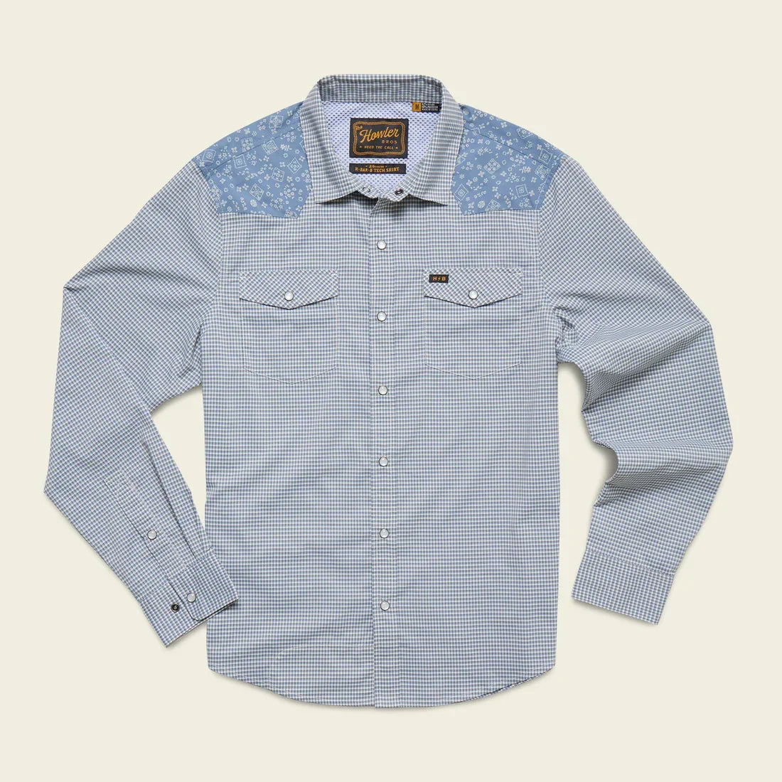 The H Bar B Tech Longsleeve by Howler Brothers is a blue and white checkered, long-sleeve shirt with light blue floral shoulder panels, pearl snaps, and UPF 35 sun protection—perfect for outdoor comfort.