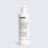 A white bottled Hair Shampoo by Blu Atlas, vegan formula, with a pump dispenser and a black and white label showing product description, hair repair directions, and cautionary notes.