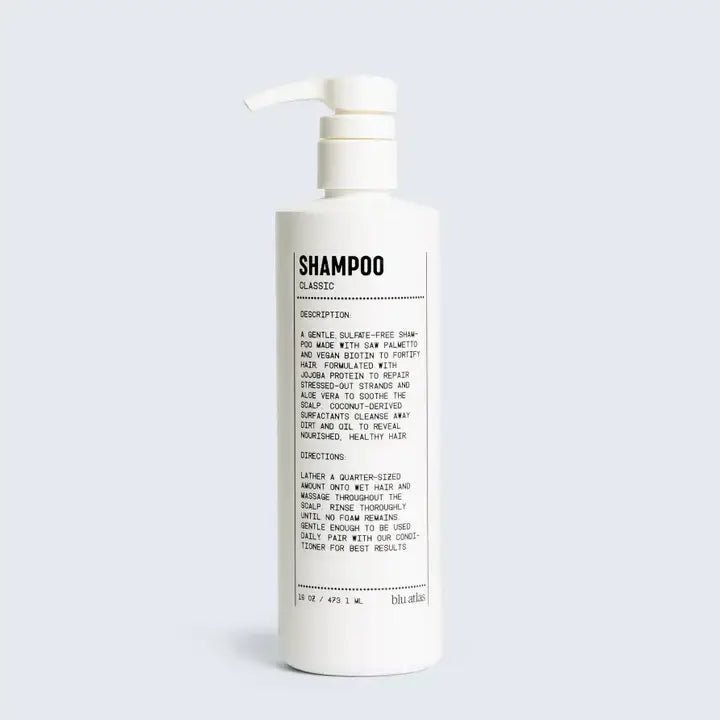 A white bottled Hair Shampoo by Blu Atlas, vegan formula, with a pump dispenser and a black and white label showing product description, hair repair directions, and cautionary notes.