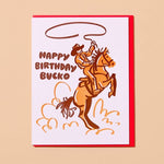 The "Happy Birthday Bucko" card by And Here We Are features a cowboy on a rearing horse and brown "Happy Birthday Bucko" text.