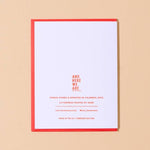 The Happy Valentines Day Card by And Here We Are features vintage lettering, a red border, and is hand letterpress printed. It highlights the woman-owned Columbus, Ohio business with contact info and “And Here We Are” at the top.
