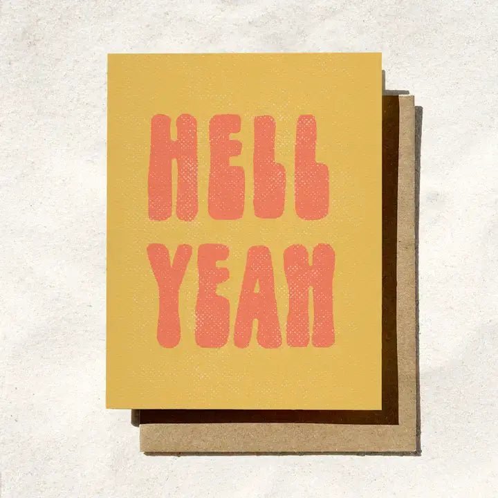 The Hell Yeah Card by Daydream Prints features bold pink "HELL YEAH" text on retro yellow, paired with a brown envelope—making it the perfect Congrats Card for any occasion.