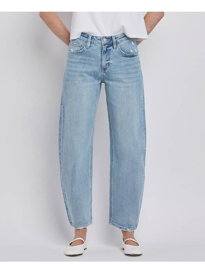 Person wearing Vervet High Rise Light Wash Barrel Leg Jeans, a white t-shirt, and white flats, standing against a plain light background.